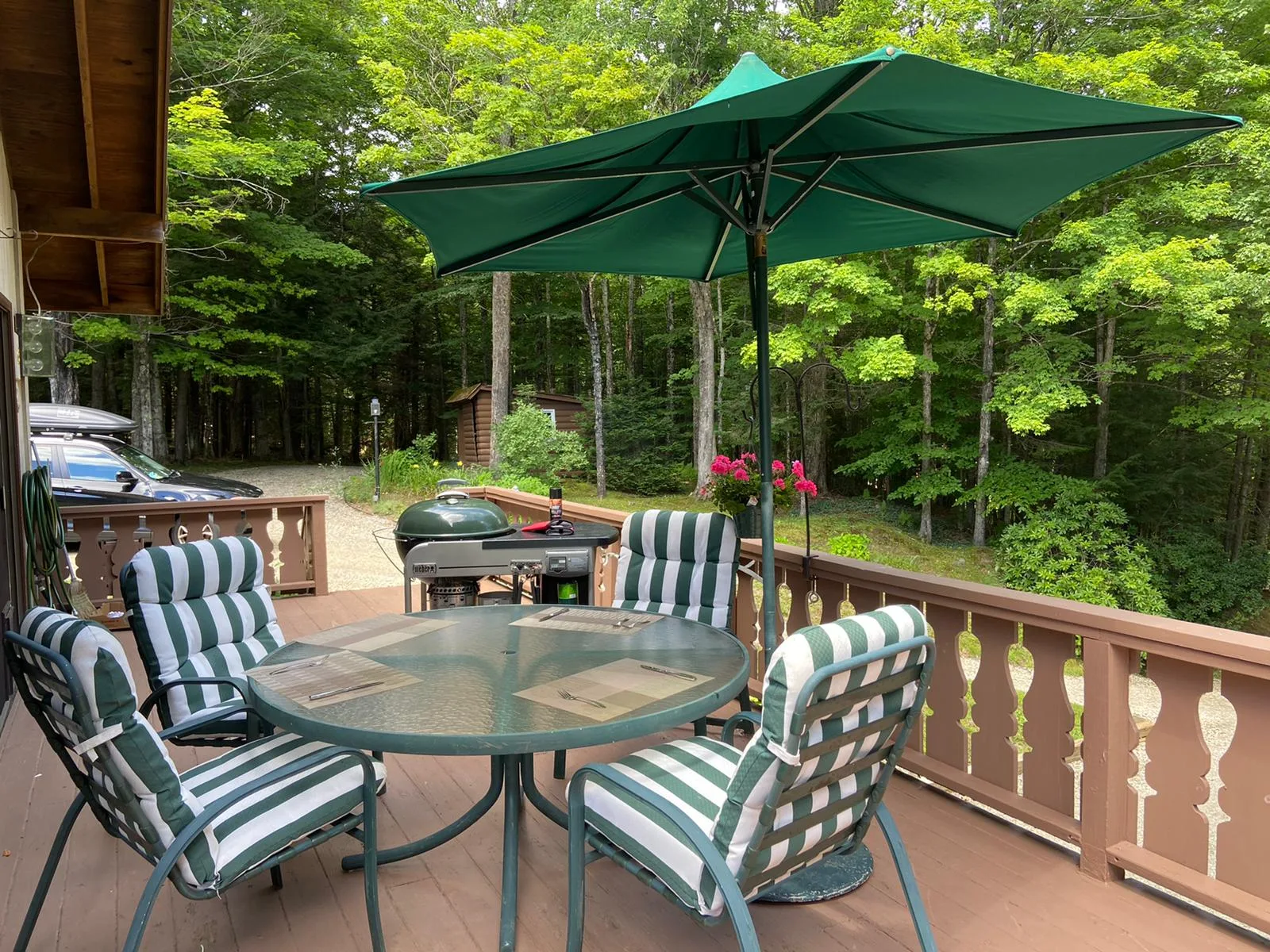 The deck with its green umbrella and grill